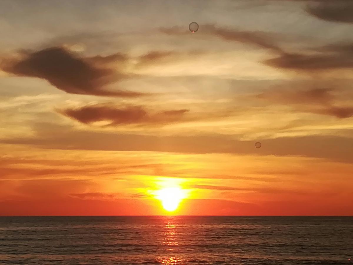 Pemandangan Pada Waktu Senja Di Laut Dengan Warna Panas - Arumi Gambar